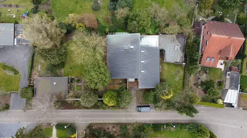 Top-down drone shot of residential rooftops and yards